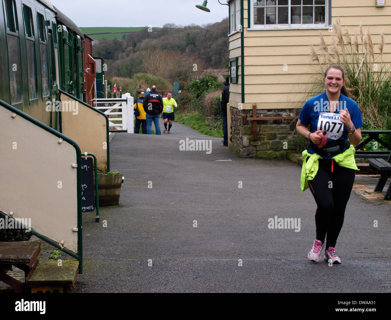 Runner passando la vecchia stazione ferroviaria sul Tarka Trail durante il Bideford mezza maratona, Devon, Regno Unito Foto Stock