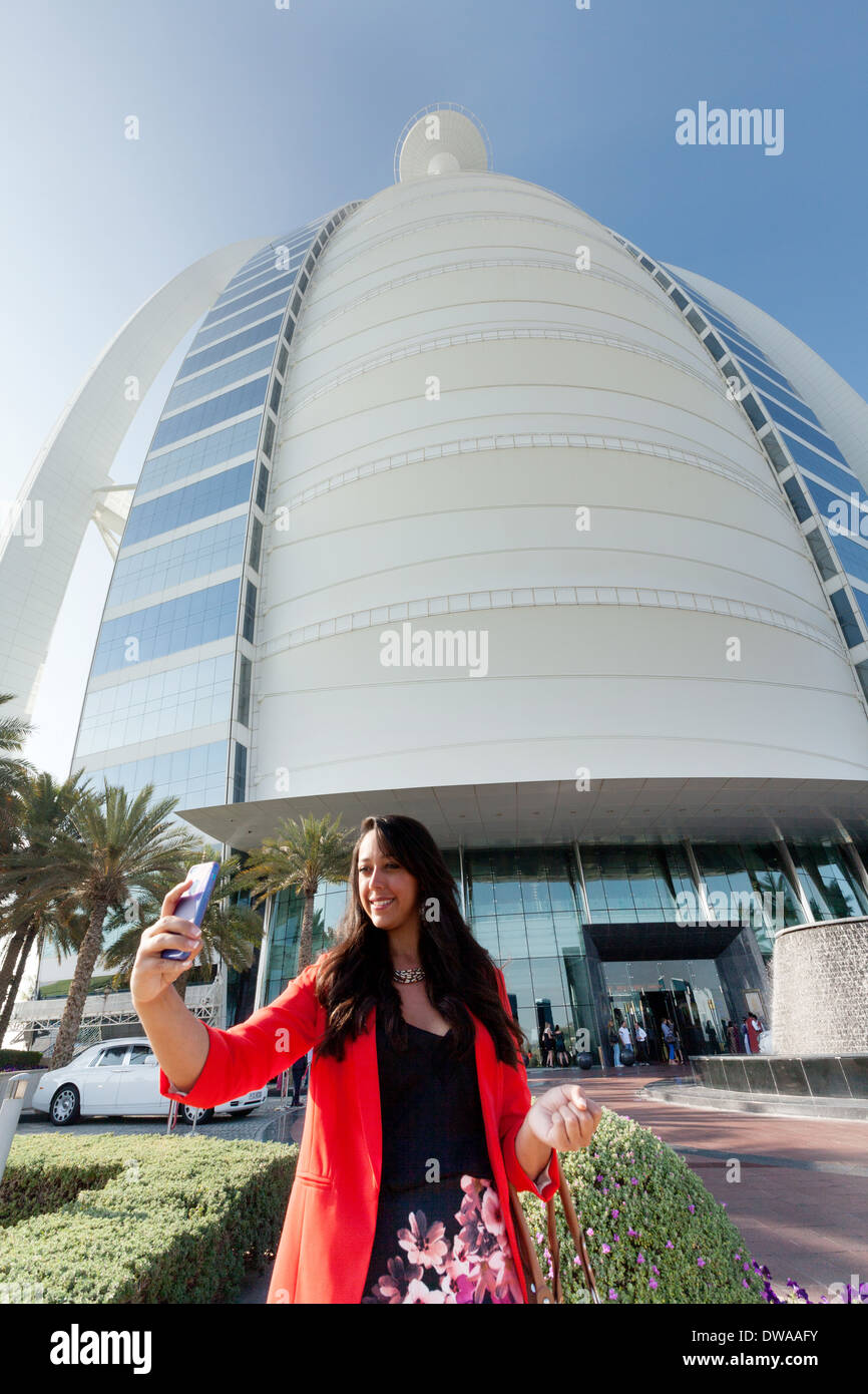 Giovane donna prendendo una foto selfie in vacanza presso l'hotel di lusso Burj al Arab Hotel, Dubai, Emirati Arabi Uniti, Emirati Arabi Uniti, Medio Oriente Foto Stock