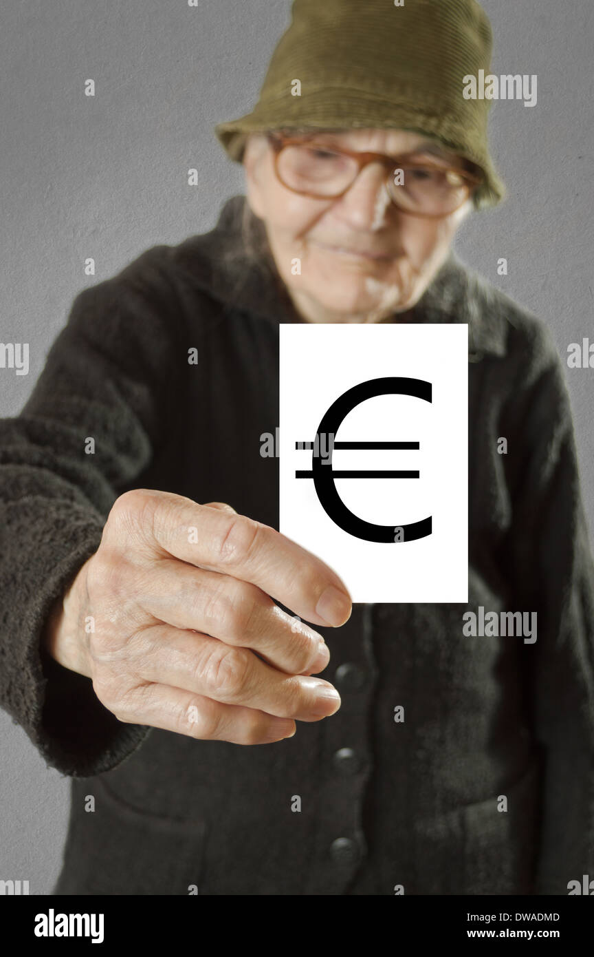 Donna anziana tenendo la scheda con stampa di euro. Il fuoco selettivo sulla carta e le dita. Foto Stock