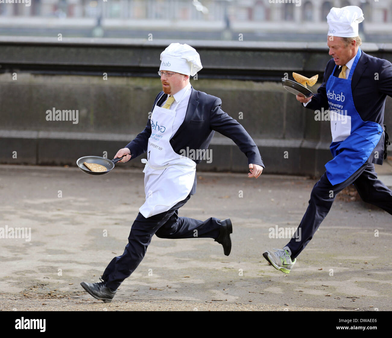 Londra, Regno Unito. 4 Marzo, 2014. Mostra fotografica di Julian Huppert MP inseguito da Lord St John. Signori la ribalta del team alla vittoria in incredibilmente uova-citando Last-Minute Scramble a Rehab Pancake parlamentare di gara il team di signori che non ha vinto la gara dal 2011, è stato vittorioso e terminato il relè evento in un tempo di 3 minuti e 56 secondi. La tradizione parlamentare, che è stato in funzione per 17 anni vede squadre di MPs, Signori e membri della stampa parlamentare Gallery competono uno contro l'altro. Credito: Oliver Dixon/Alamy Live News Foto Stock