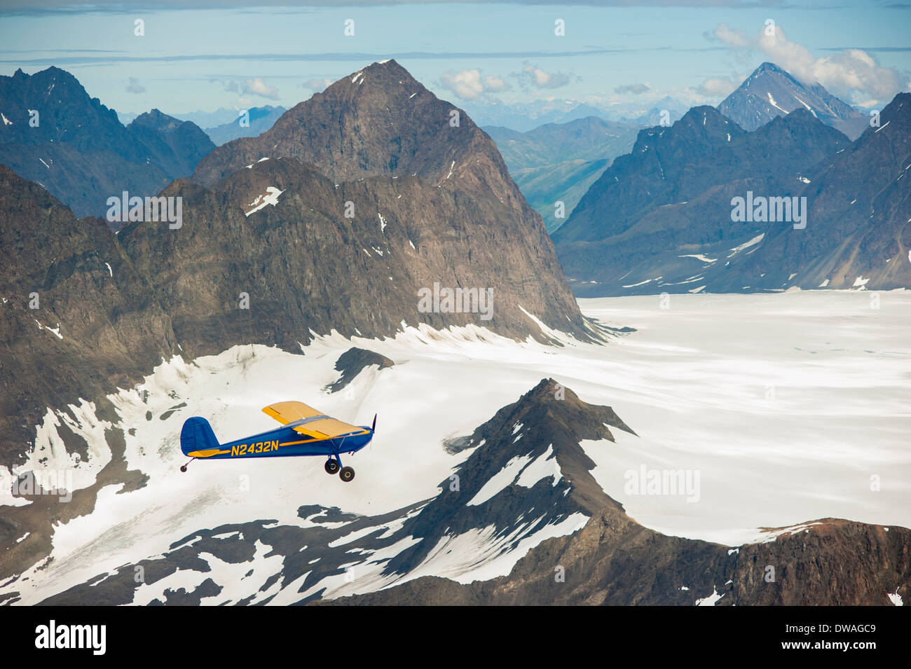 Dave Souza battenti il suo blu Cessna 140 sopra Eklutna e Whiteout ghiacciai, Chugach Mountains, Alaska Foto Stock