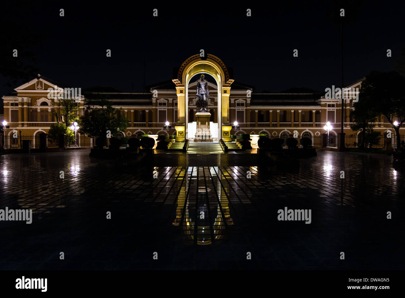 Palazzo Saranrom (Thai Ministero degli Affari Esteri) durante la notte con una statua del re si riflette sul pavimento di piastrelle. Foto Stock