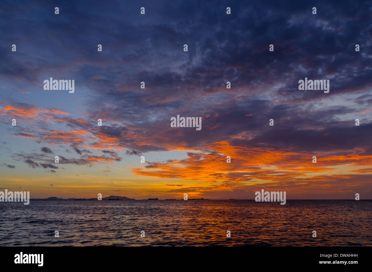 Il tramonto oro lucente colore dietro una marina con una bella nuvola Foto Stock