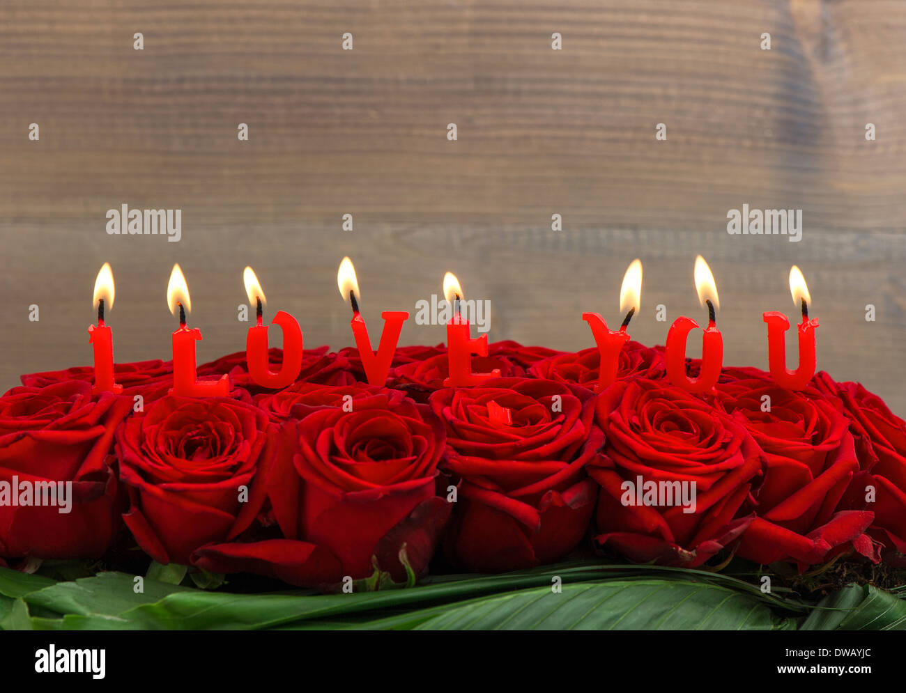 Rose rosse e candele accese facendo ti amo. floreale. messa a fuoco selettiva Foto Stock