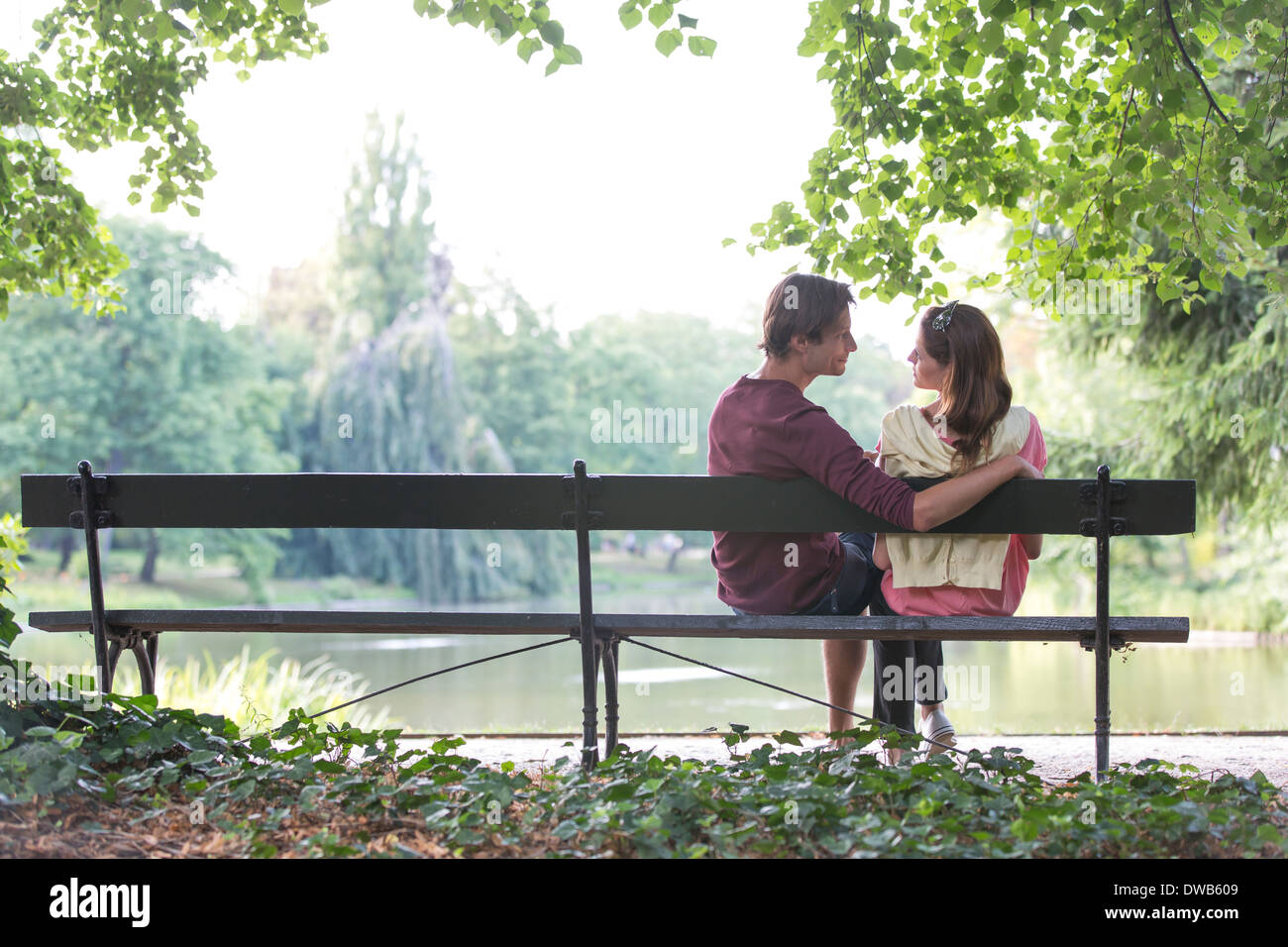 Romantico coppia giovane seduto su una panchina nel parco sul lago di garda Foto Stock