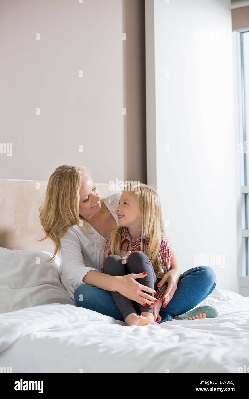 Donna felice e figlia guardando ogni altro nella camera da letto Foto Stock