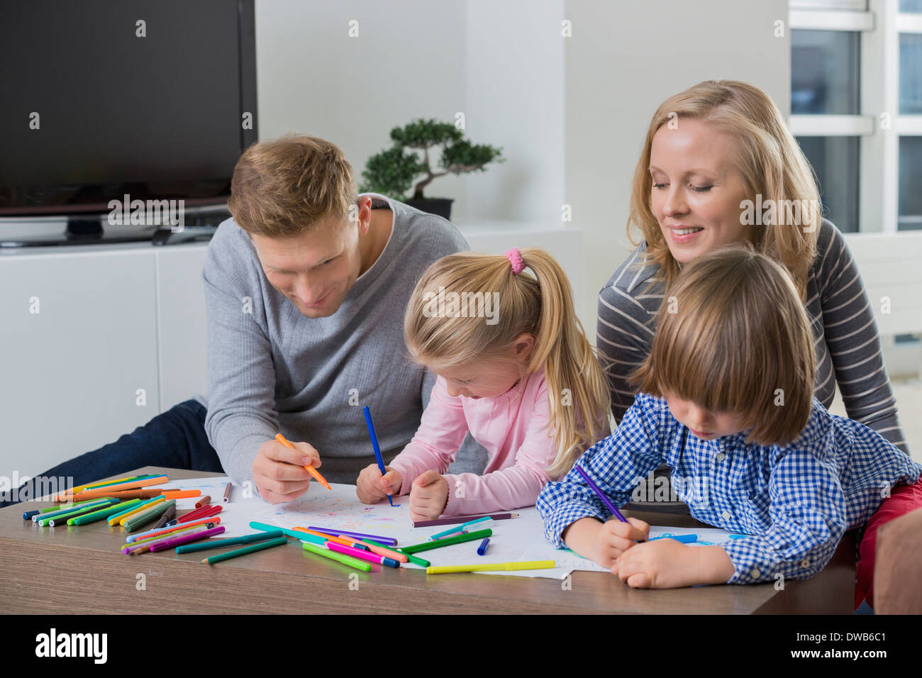 I genitori con bambini disegno insieme a casa Foto Stock