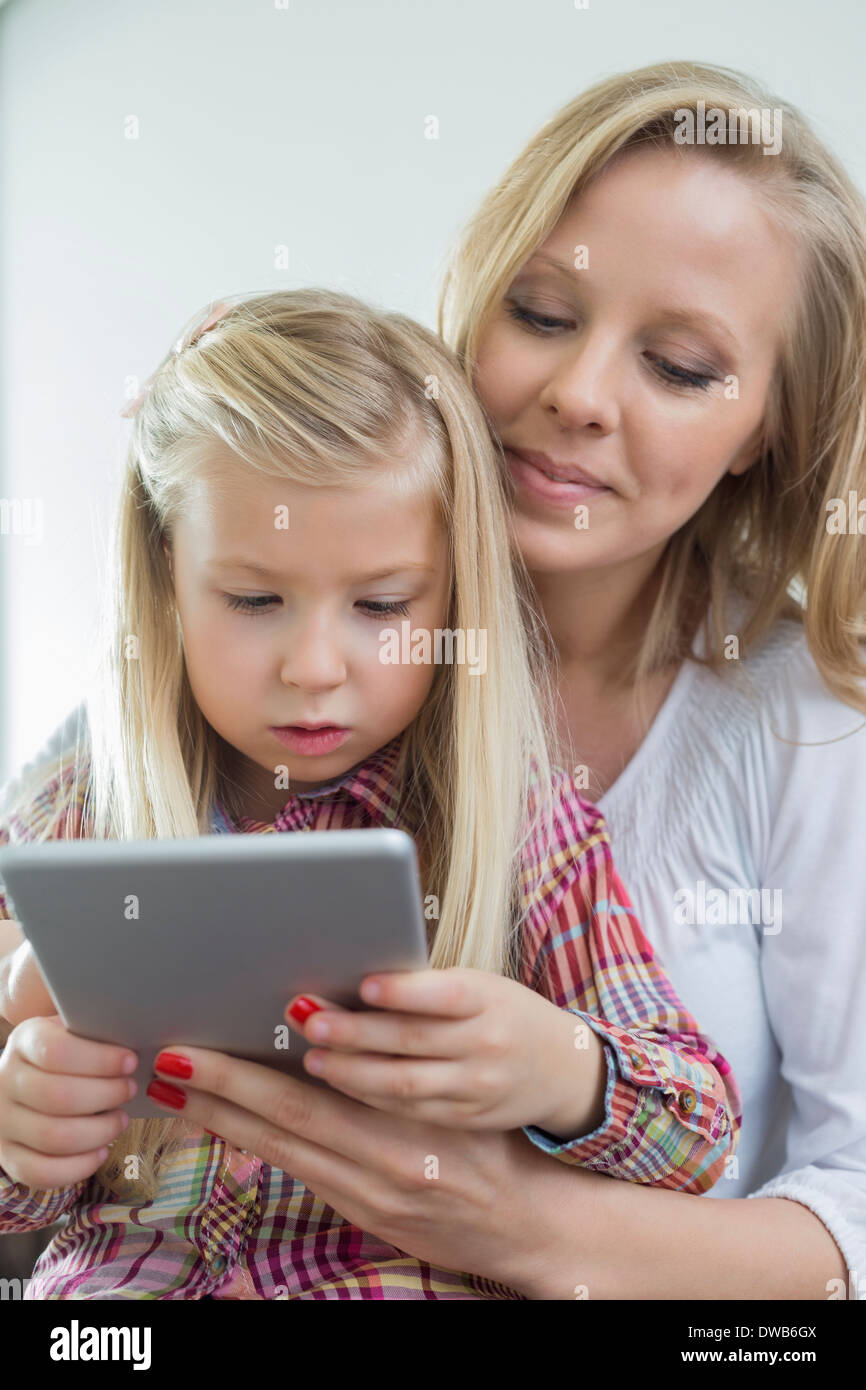 Amare la donna con la figlia con tavoletta digitale in casa Foto Stock