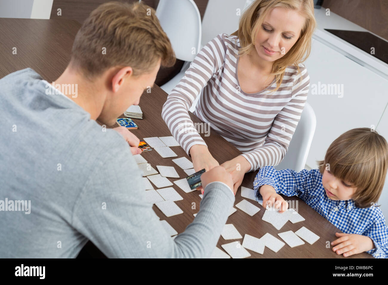 Famiglia di tre carte da gioco a casa Foto Stock