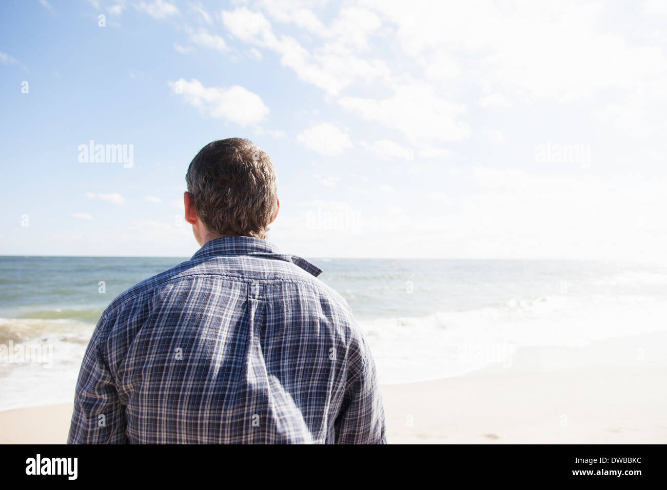 Uomo solo che guarda verso il mare immagini e fotografie stock ad alta