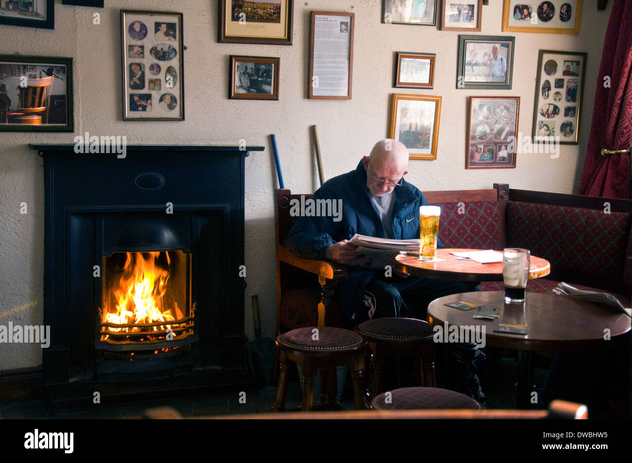 L'uomo leggendo un giornale in Corner House Bar a Ardara County Donegal Irlanda Foto Stock