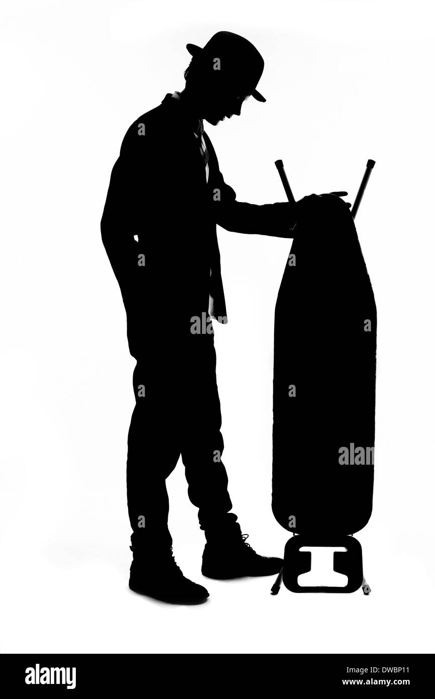Silhouette di giovane con cappello bowler holding asse da stiro Foto Stock