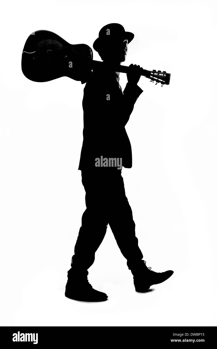 Silhouette di giovane con cappello bowler tenendo la chitarra sulla sua spalla Foto Stock