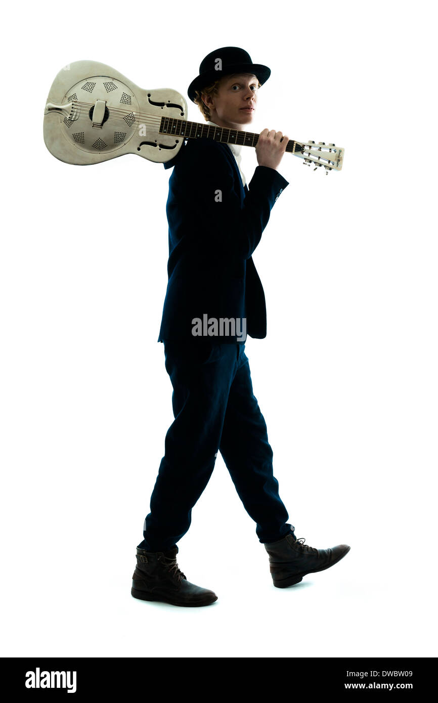 Giovane uomo con cappello bowler tenendo la chitarra sulla sua spalla Foto Stock