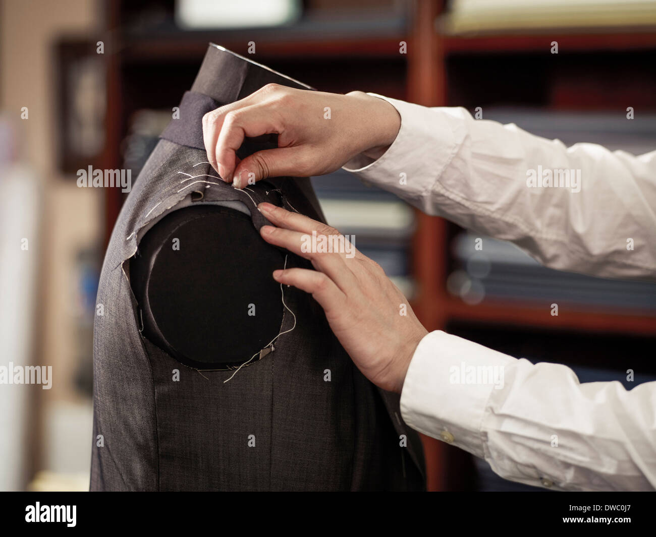 Adattare il pinning indumento nella tradizionale negozio di sartoria Foto Stock