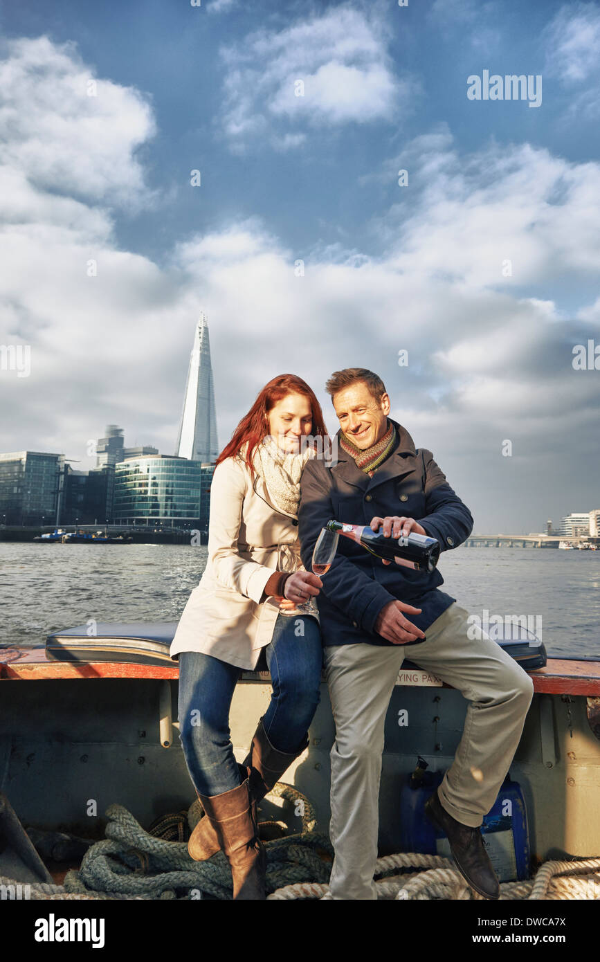 Coppia romantica sul Tamigi la condivisione di barca champagne rosato, London, Regno Unito Foto Stock