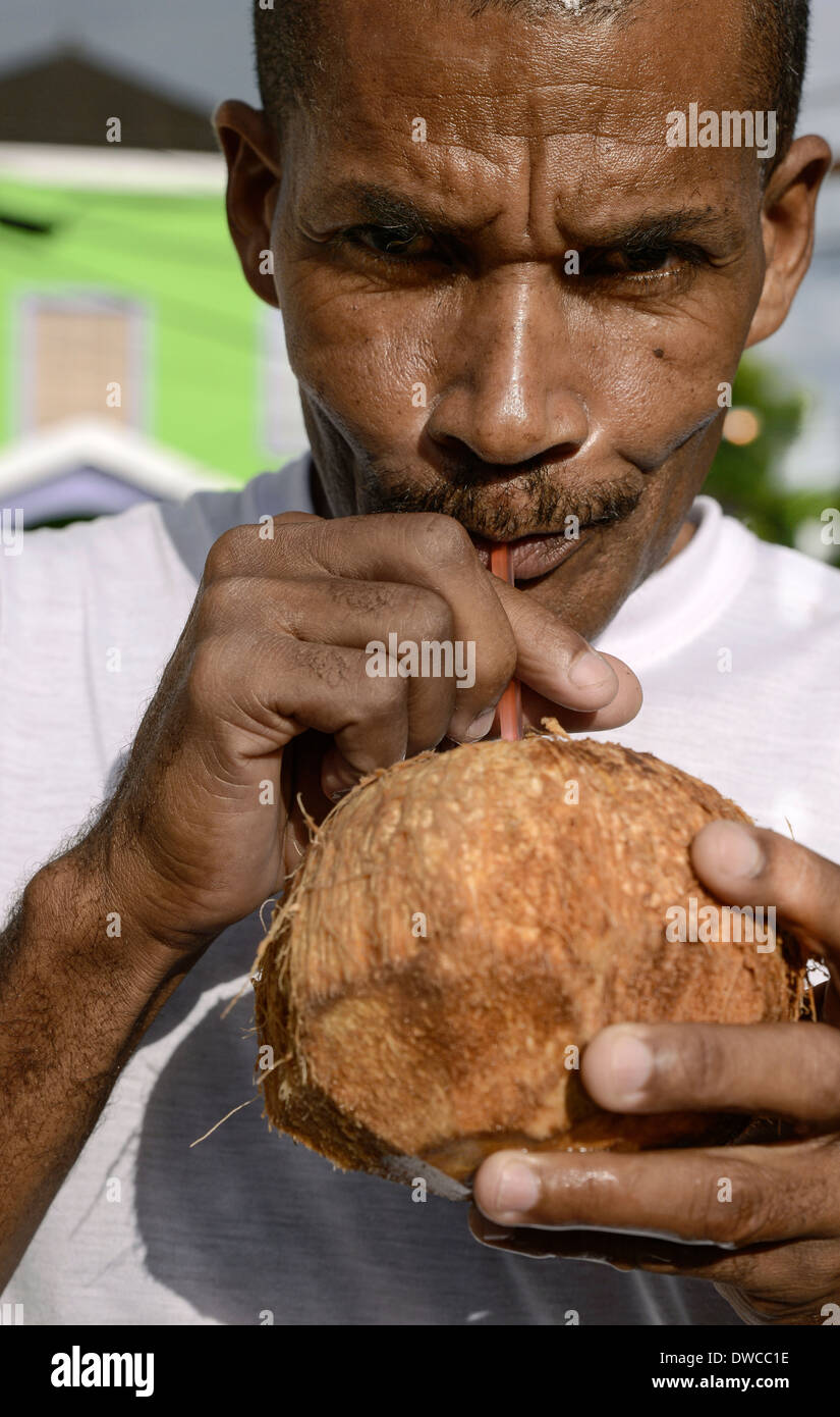 Il giamaicano uomo gode di una acqua di cocco jelly, Negril, Giamaica Foto Stock
