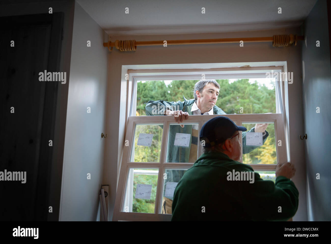 Padre e figlio costruttori installazione nuova finestra in casa Foto Stock