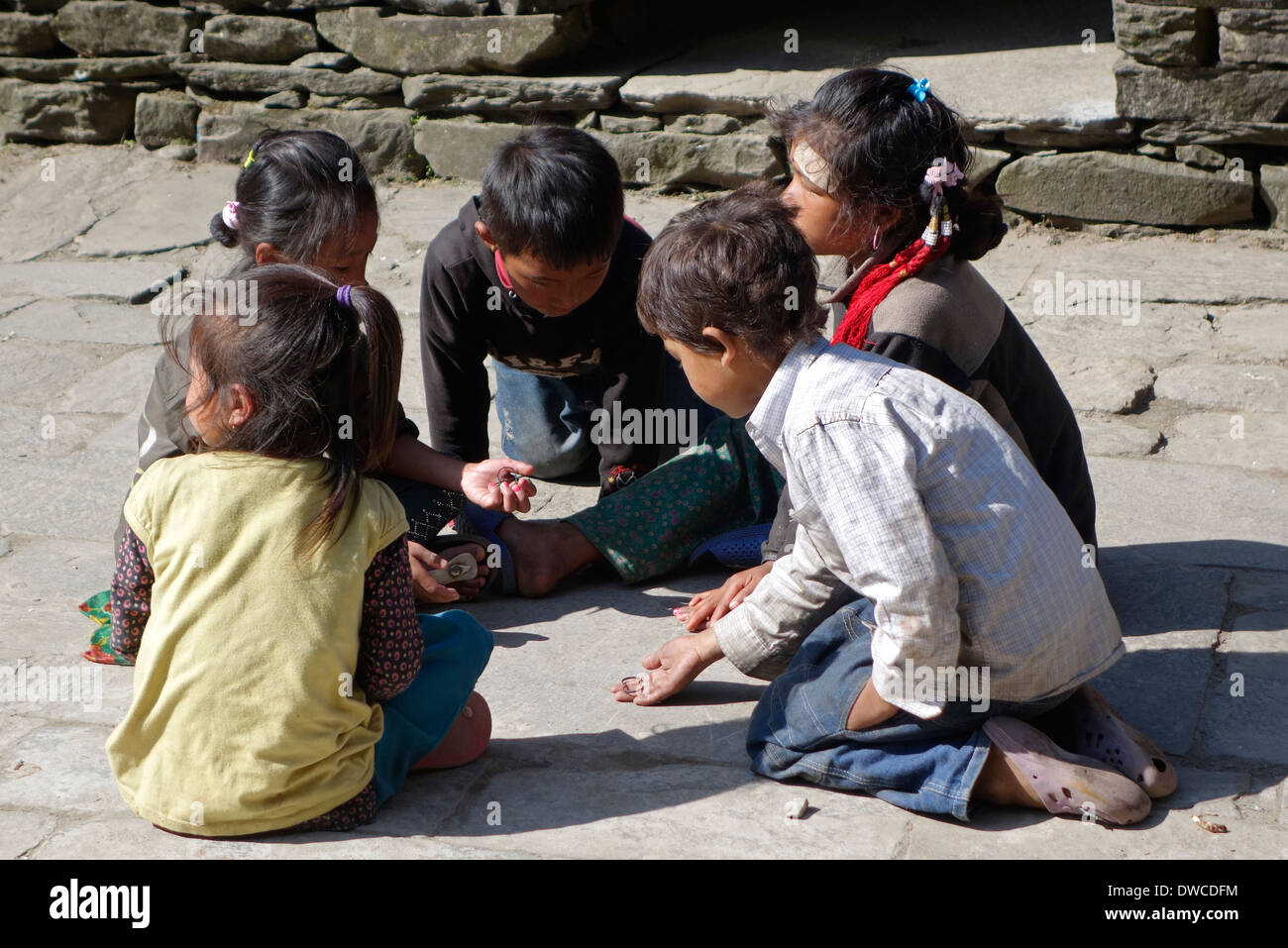 Bambini nepalesi giocando una partita nel villaggio di Jagat, regione di Manaslu del Nepal. Foto Stock