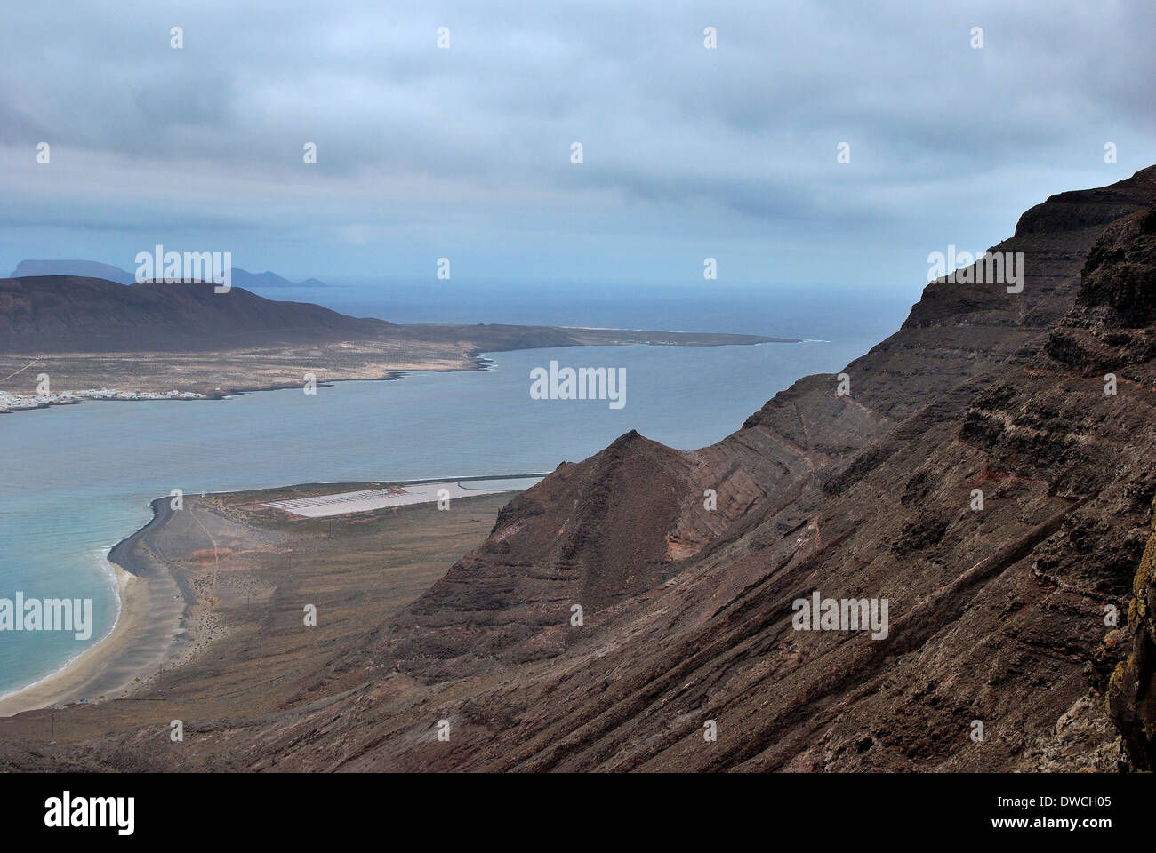 Scogliere di Famara e le saline di fronte all'isola di Graciosa. Lanzarote, Spagna. Foto Stock