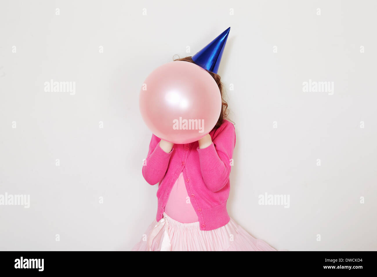 Ragazza con palloncino rosa nella parte anteriore del viso Foto Stock