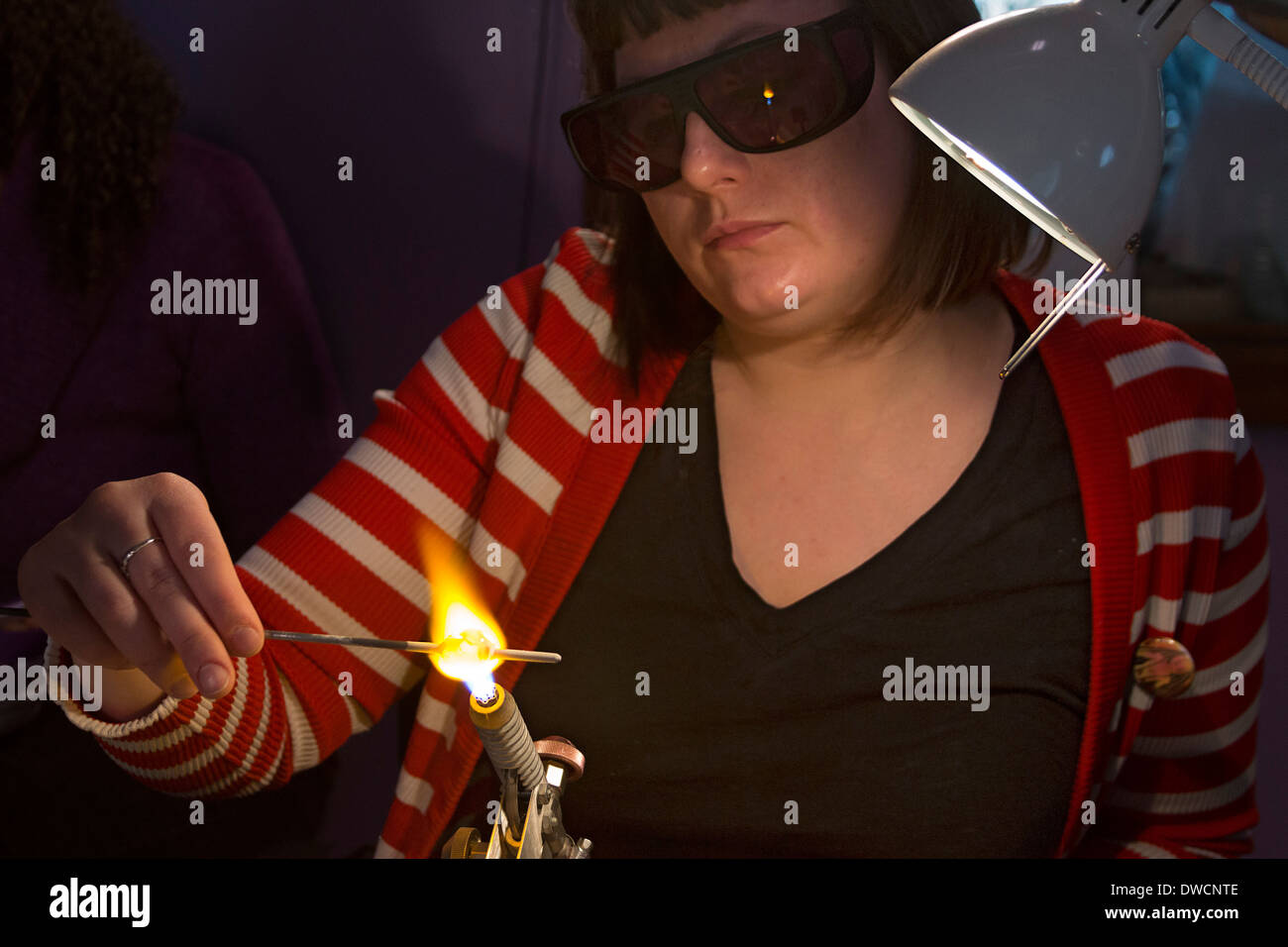 La donna fa di perline di vetro a Liquid Light Art Glass Studio di Logan, Ohio. Foto Stock