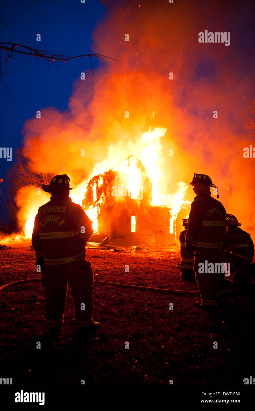 Conover, NC, Stati Uniti d'America. 4 Marzo, 2014. Il Conover Vigili del Fuoco in Conover North Carolina detiene una combustione controllata fire al crepuscolo su roccia Barn Road Marzo 4, 2014. Credito: Ken Howard/Alamy Live News Foto Stock