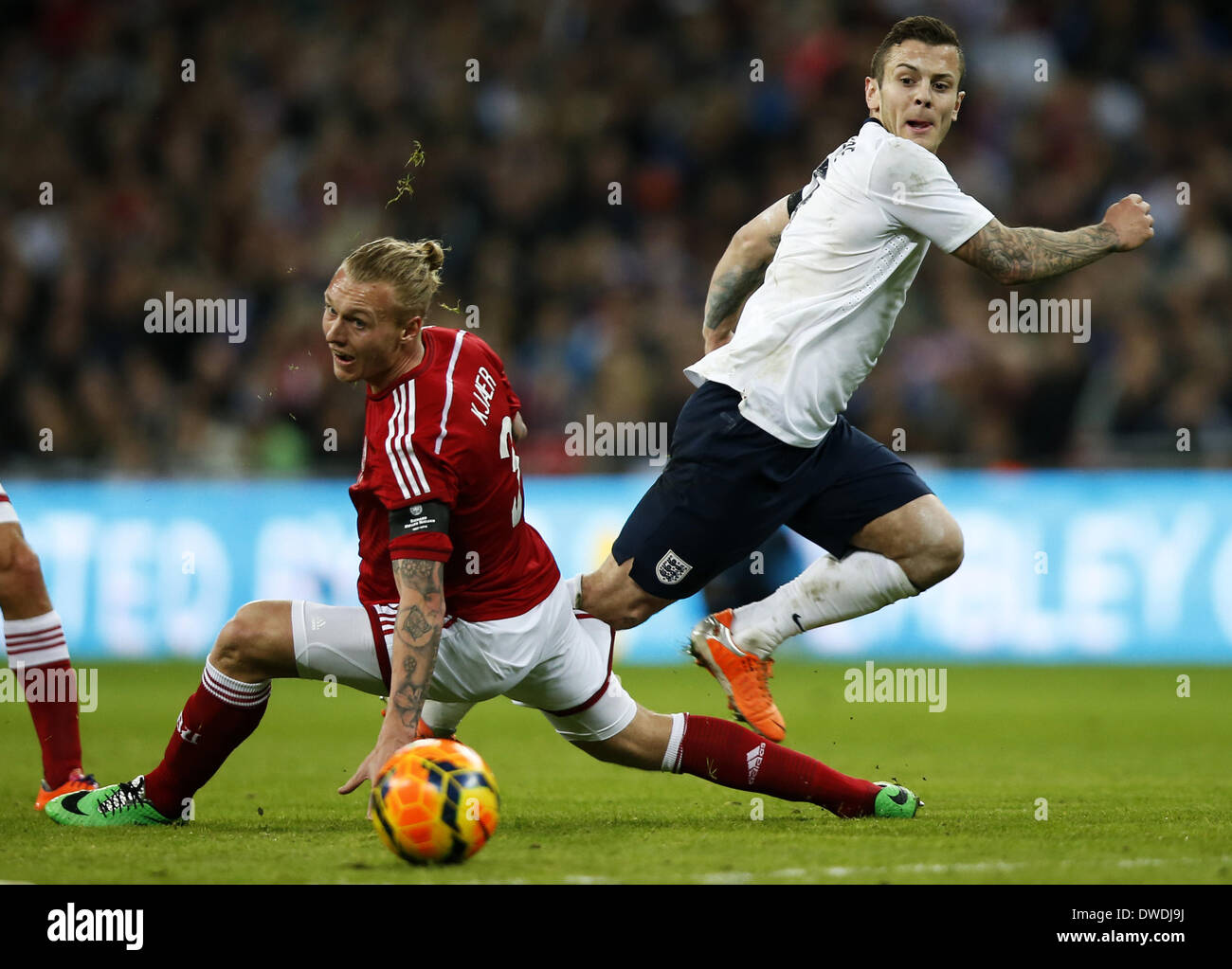 Londra, Regno Unito. 5 Mar 2014. Jack Wilshere (R) dell'Inghilterra passa la palla durante un amichevole internazionale partita di calcio tra Inghilterra e Danimarca allo Stadio di Wembley a Londra, in Gran Bretagna il 5 marzo 2014. In Inghilterra ha vinto 1-0. Credito: Wang Lili/Xinhua/Alamy Live News Foto Stock