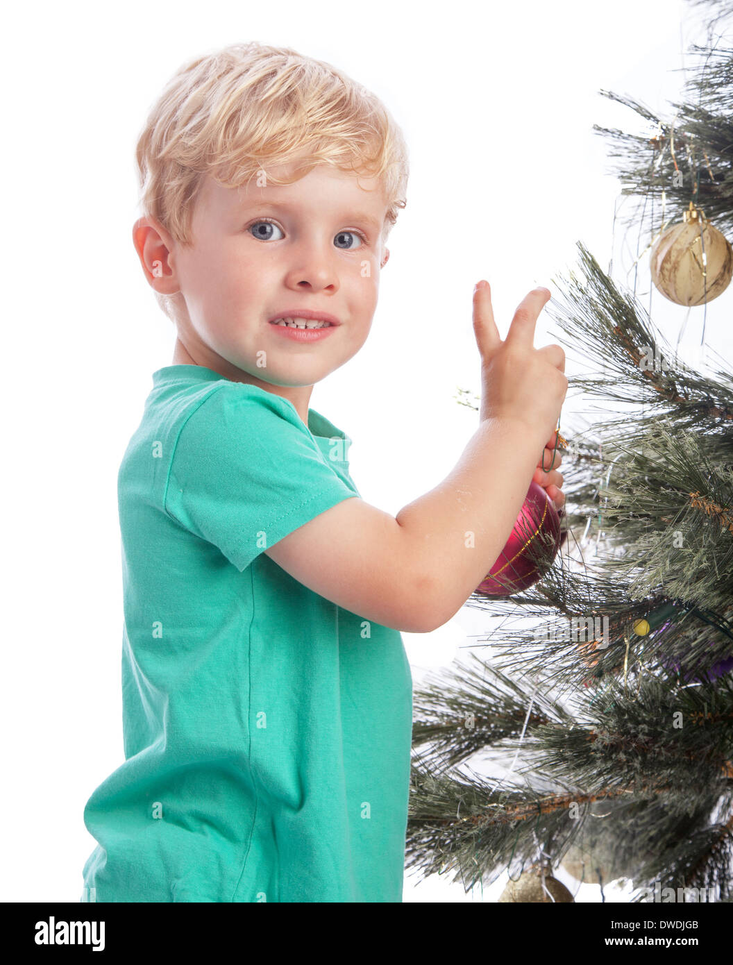 Preschooler sorridente alla telecamera la decorazione di un albero di Natale. Foto Stock