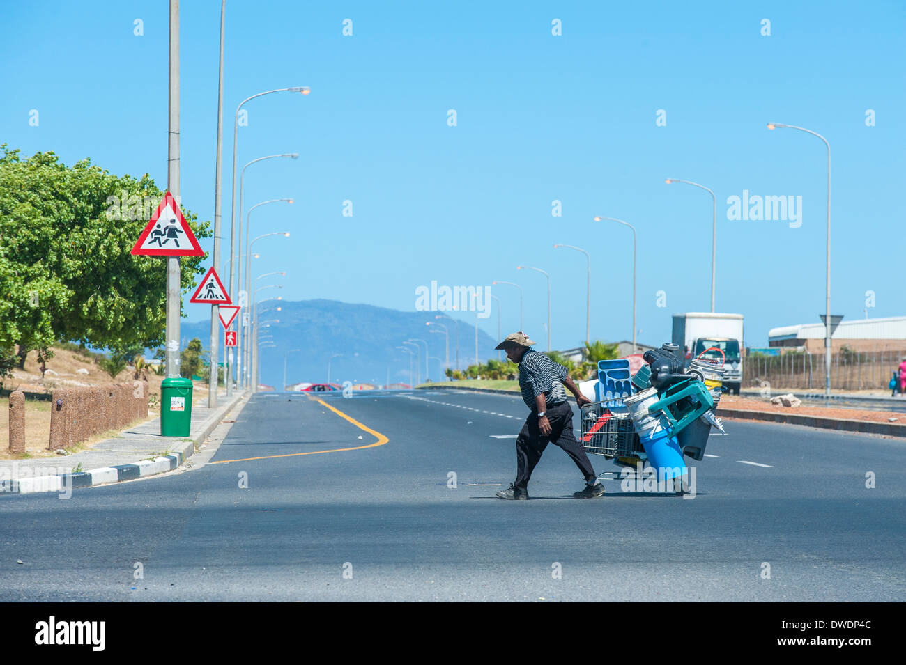 Uomo con carrello la raccolta di materiali in plastica per fare una vita, Mitchell's Plain, Cape Town, Sud Africa Foto Stock