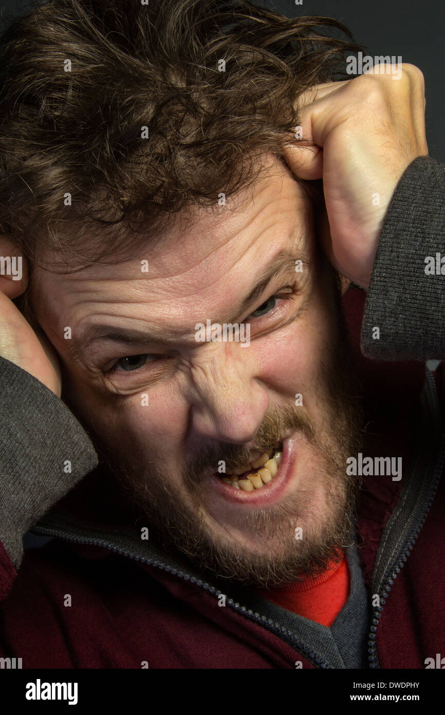 Un uomo arrabbiato con un caratteraccio strappando i suoi capelli fuori. Foto Stock
