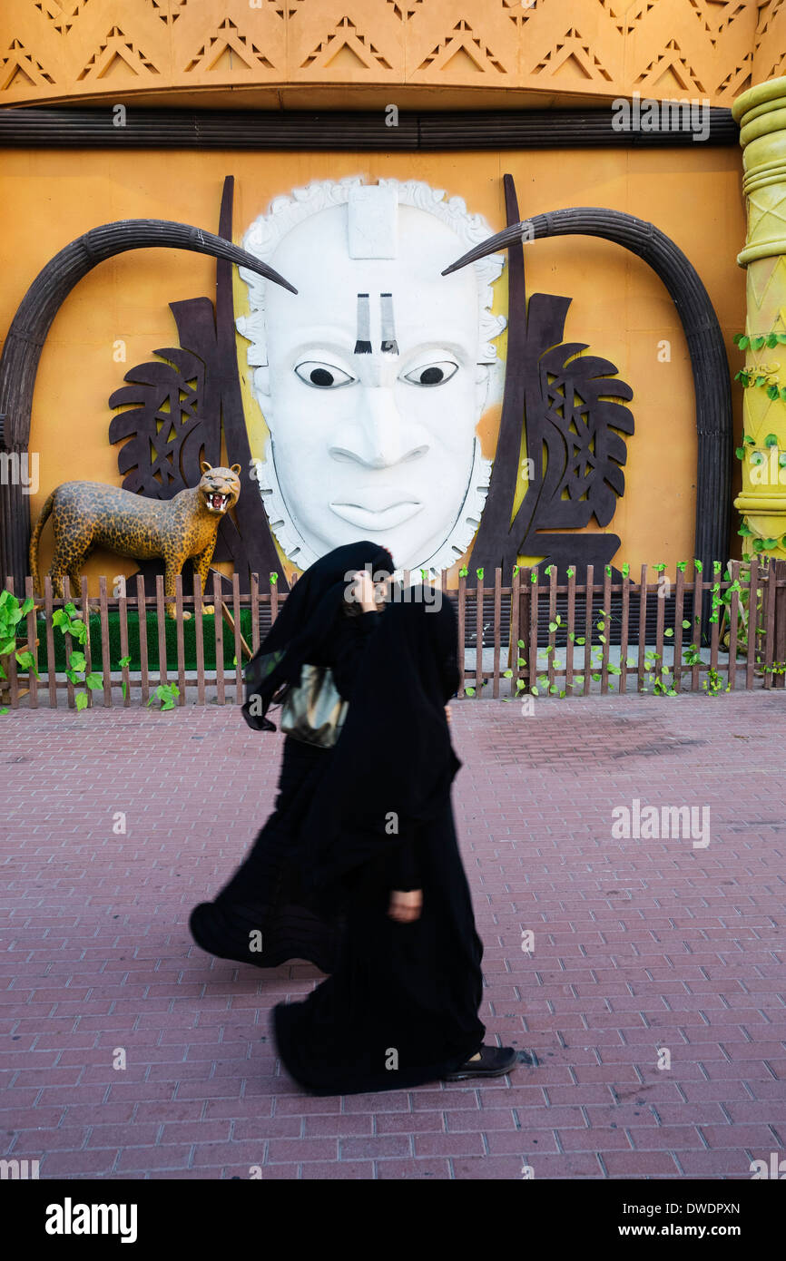 Le donne a piedi passato Africa Pavilion al Villaggio Globale turistico culturali attrazione in Dubai Emirati Arabi Uniti Foto Stock