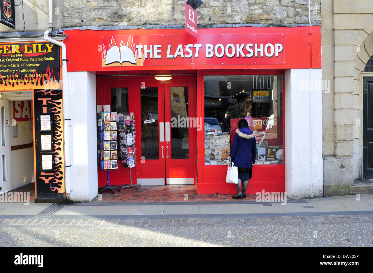 Una donna guarda una vetrina di un bookshop, Oxford, Regno Unito Foto Stock