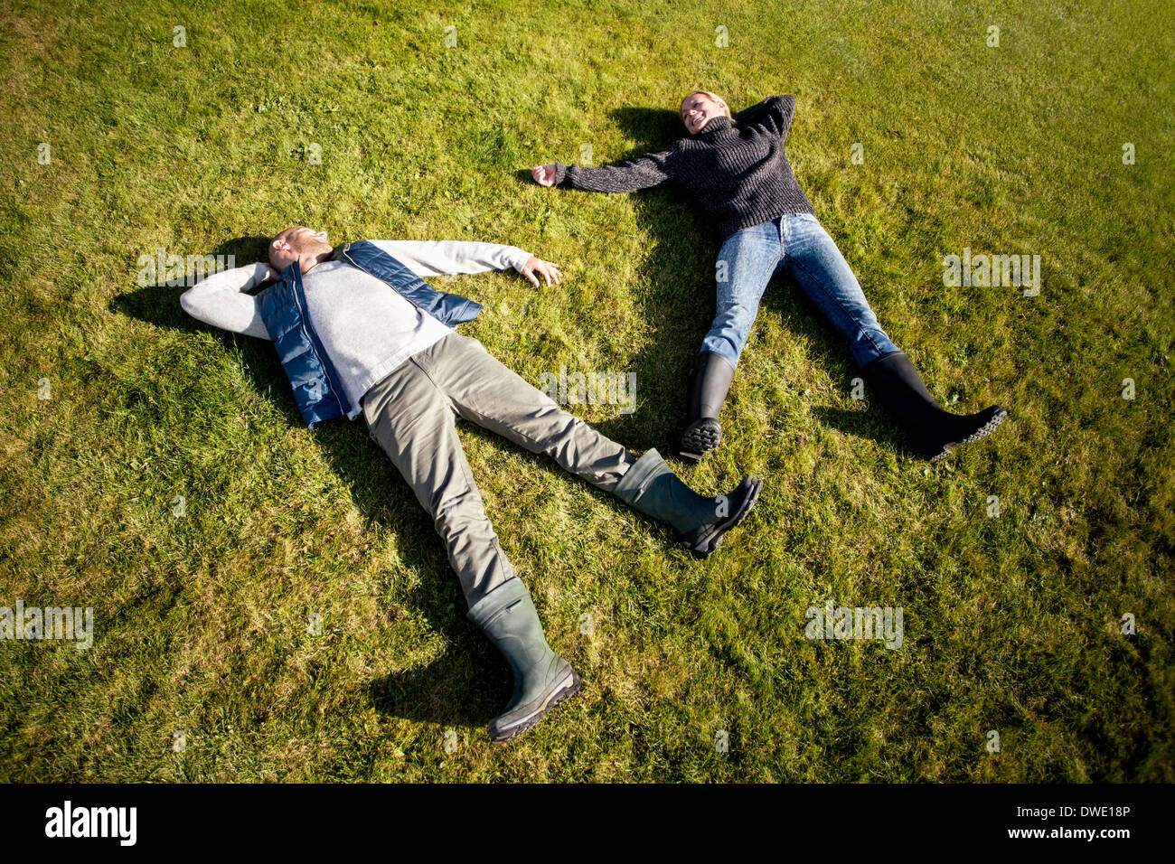 Angolo di Alta Vista della coppia matura sdraiati sull'erba Foto Stock