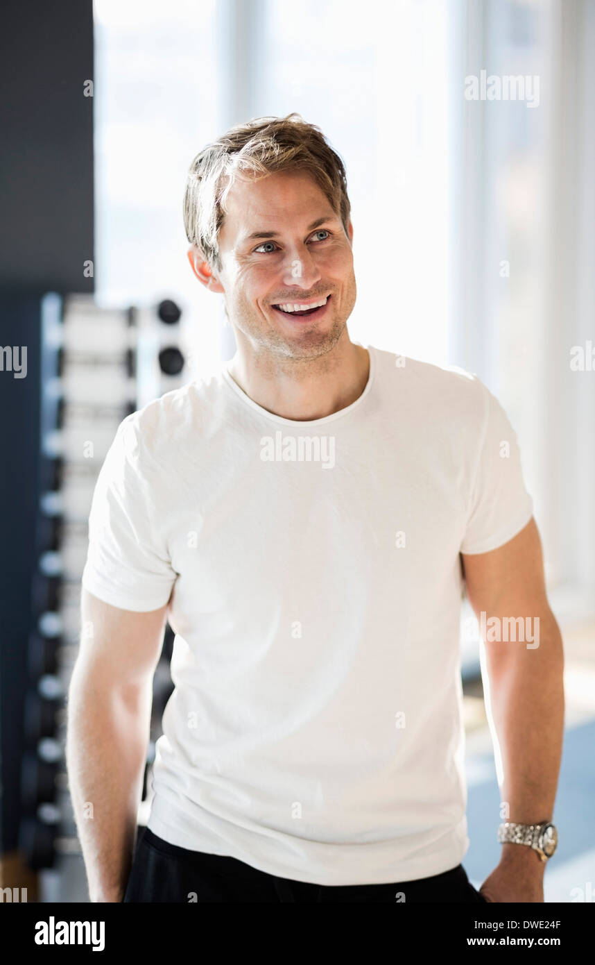 Felice maschio istruttore di fitness in palestra Foto Stock