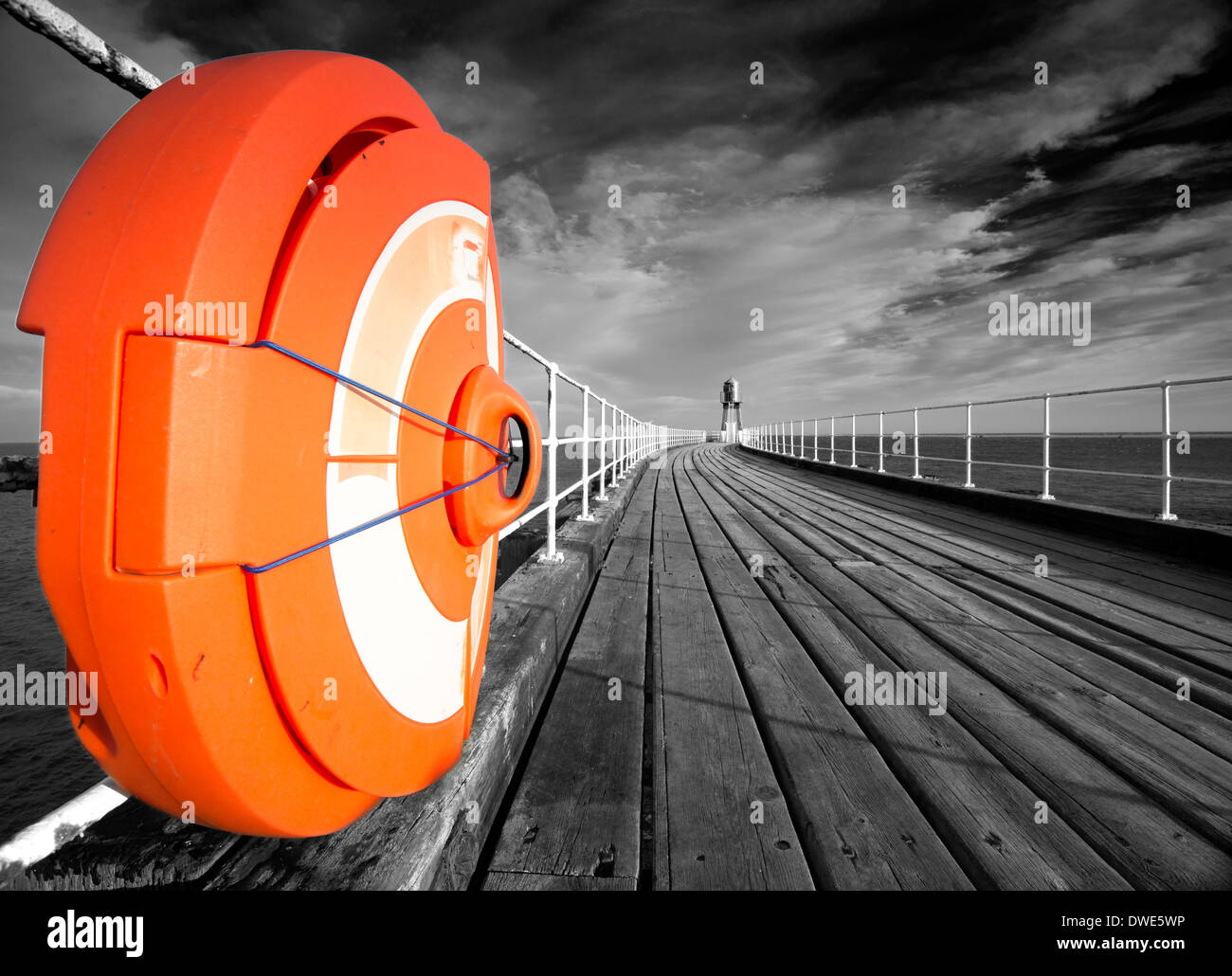 Whitby Pier, con salvagente arancione evidenziata contro il bianco e nero, North Yorkshire England Regno Unito Foto Stock