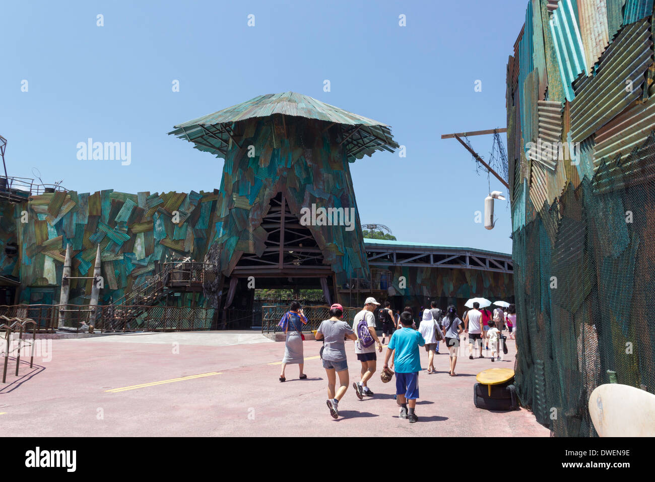 I visitatori diretti verso Waterworld attrazione per gli Universal Studios Park in Sentosa, attraverso qualche decorazione esterna per mostrare Foto Stock