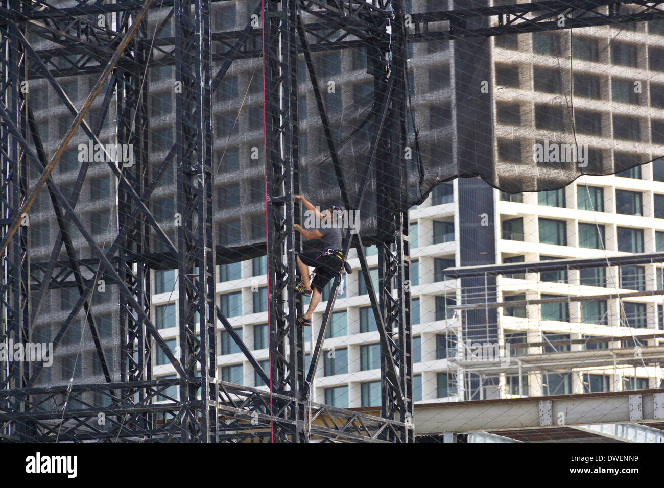 L'uomo salendo una scaletta di acciaio nella zona della Marina di Singapore, parte di alcune attività di costruzione accadendo Foto Stock