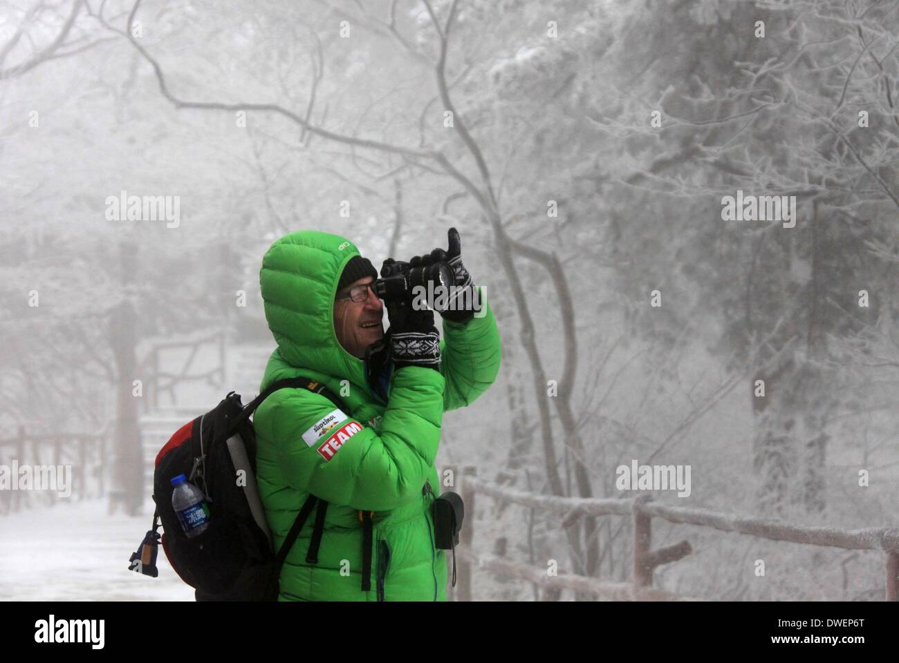 Huangshan, cinese della provincia di Anhui. 6 Mar 2014. Un turista prende le foto della neve scenario in montagna Huangshan, est cinese della provincia di Anhui, 6 marzo 2014. Credito: Shi Guangde/Xinhua/Alamy Live News Foto Stock