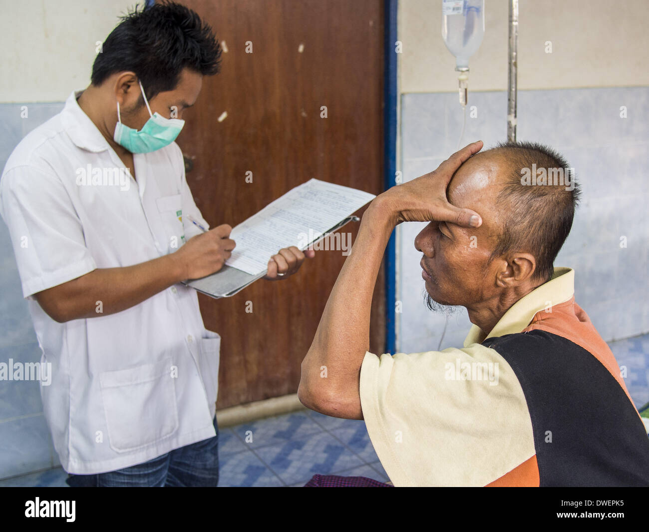 Mae Sot, Tak, Thailandia. 5 Mar 2014. Un paziente descrive il suo mal di testa ad un medic al Mae Tao Clinic. Il Mae Tao clinica offre assistenza sanitaria a oltre 150.000 sfollati birmani per anno ed è il principale fornitore di servizi sanitari per birmani lungo il confine Thai-Myanmar. Le riforme in Myanmar hanno alllowed alle ONG di operare in Myanmar, come risultato di numerose ONG sono lo spostamento di risorse per le operazioni in Myanmar, lasciando birmani immigrati e rifugiati in Thailandia vulnerabili. © Jack Kurtz/ZUMAPRESS.com/Alamy Live News Foto Stock