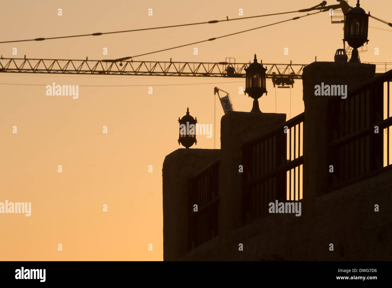 Il Qatar costruzione cantiere gru al tramonto nel deserto sillouette Foto Stock