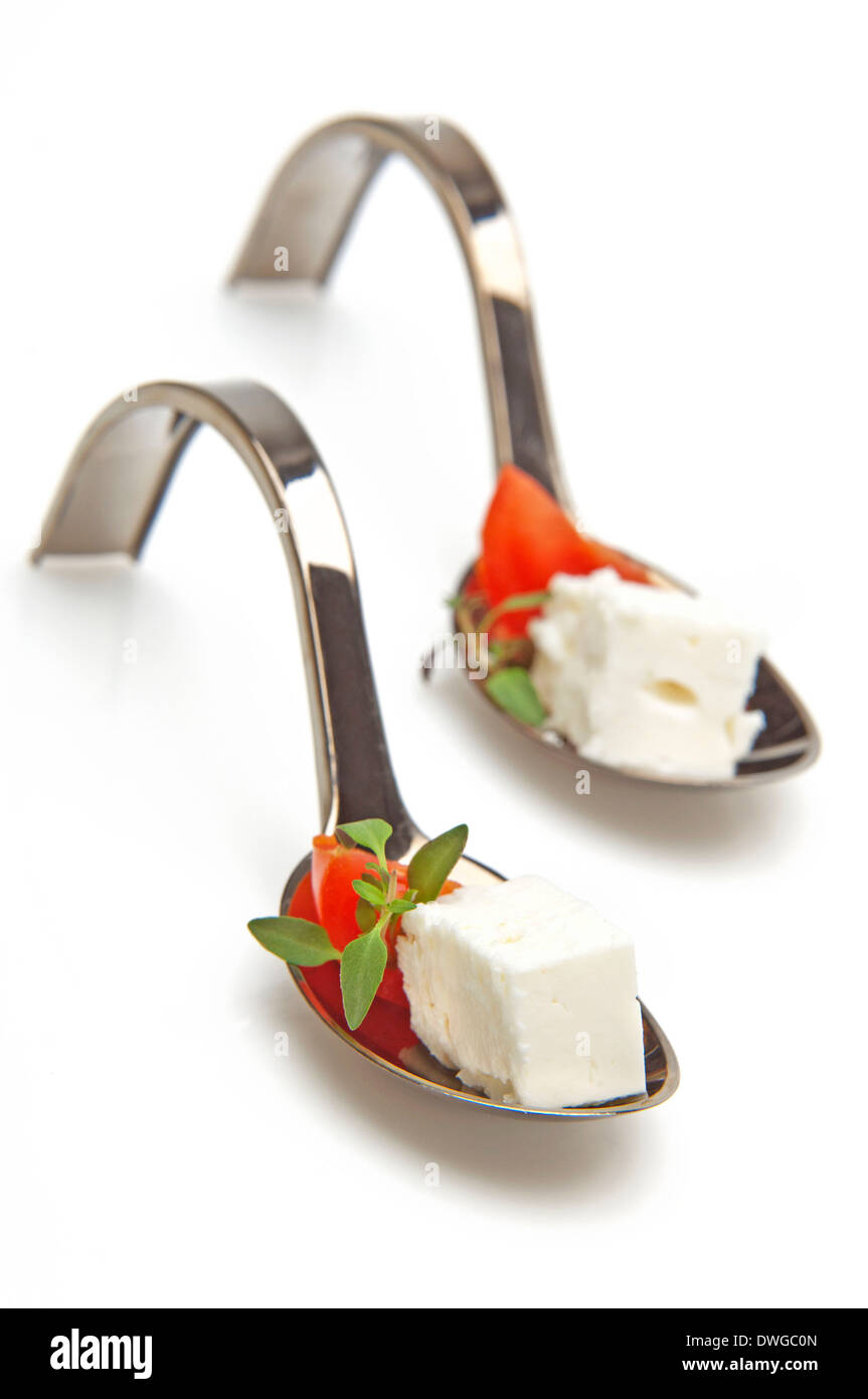 Il formaggio feta,pomodoro e origano su un cucchiaio-un antipasto con un sapore mediterraneo Foto Stock