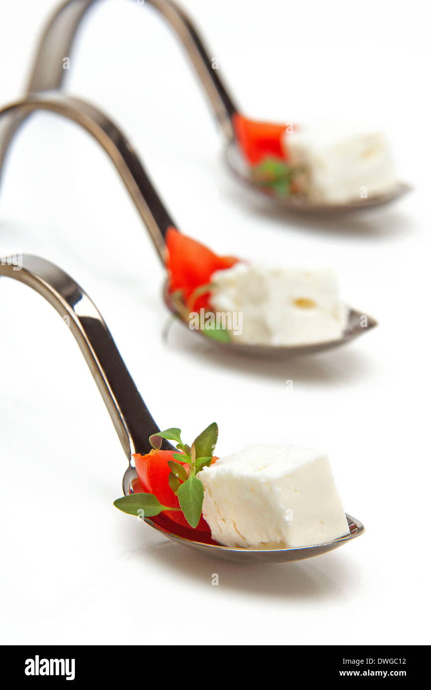 Il formaggio feta,pomodoro e origano su un cucchiaio-un antipasto con un sapore mediterraneo Foto Stock