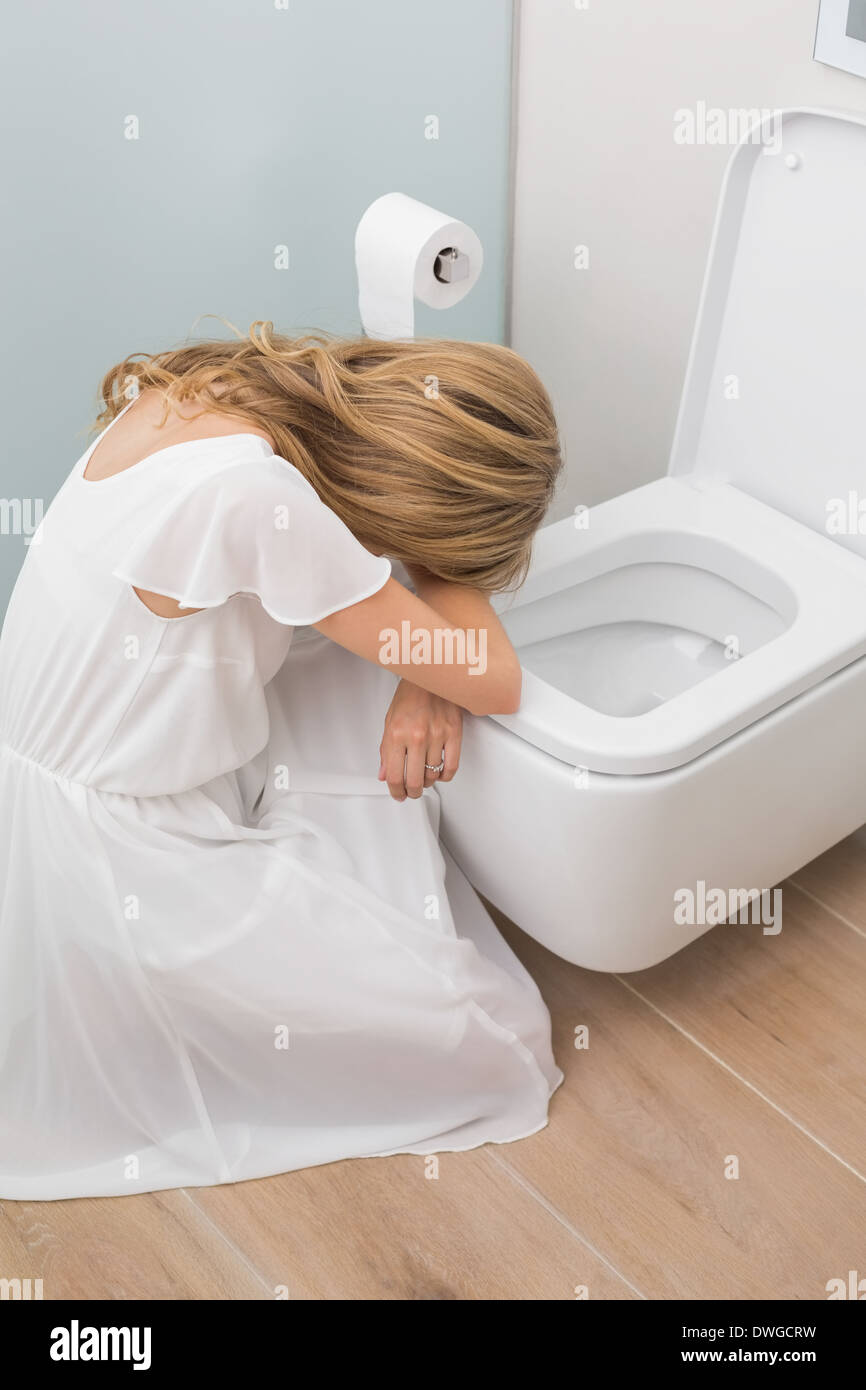 Malati giovane donna seduta nel wc Foto stock - Alamy