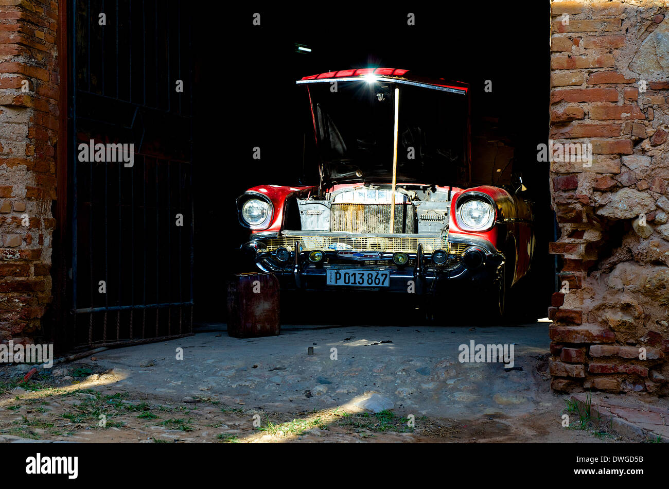 Vecchio rosso americano auto con apertura cofano anteriore in un garage in Trinidad, Cuba Foto Stock