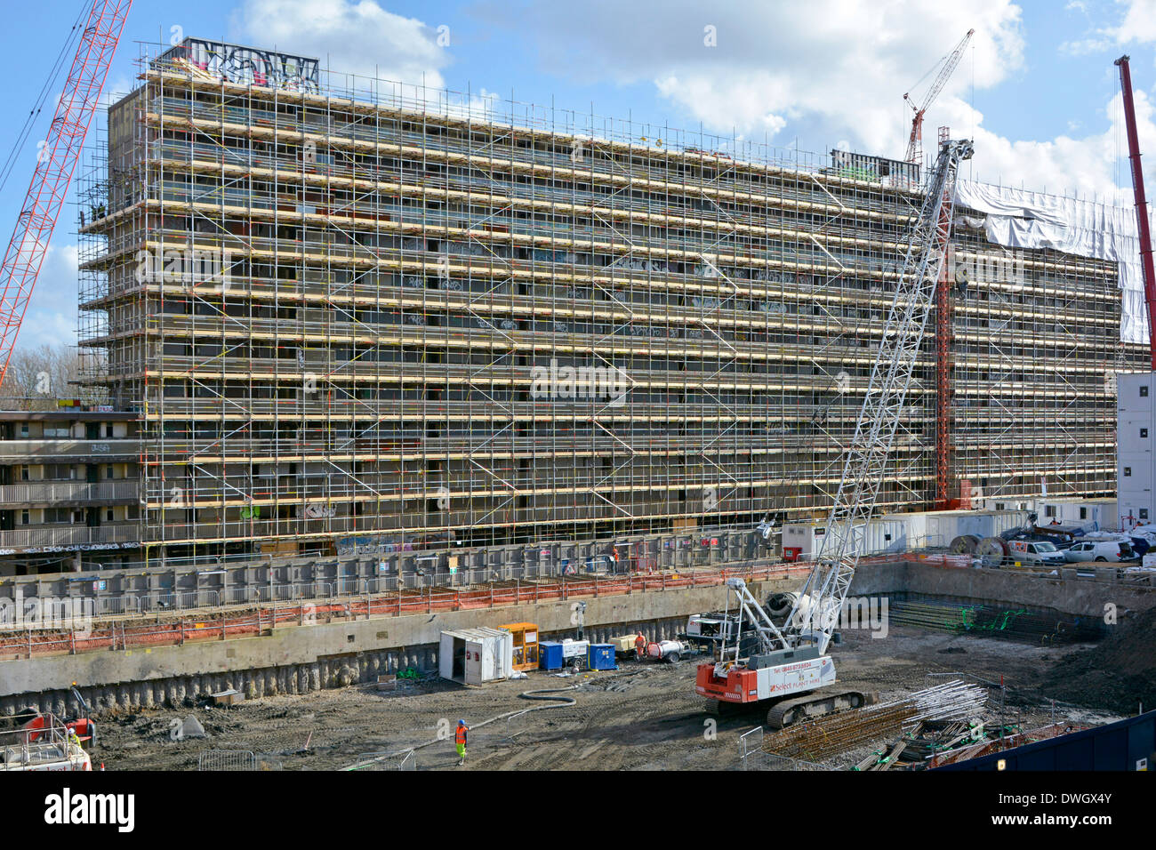 Impalcatura intorno Heygate Estate sociale blocco alloggiamento di preparazione per i lavori di demolizione Lavori di fondazione su precedentemente cancellato area sud di Southwark Londra Inghilterra Foto Stock
