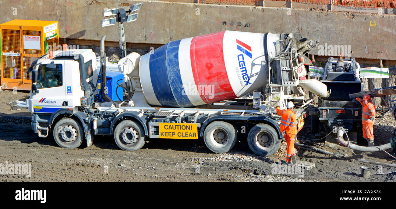 Pronta consegna misti di camion in scarico pompa per calcestruzzo fondazione durante le operazioni di impilamento Foto Stock