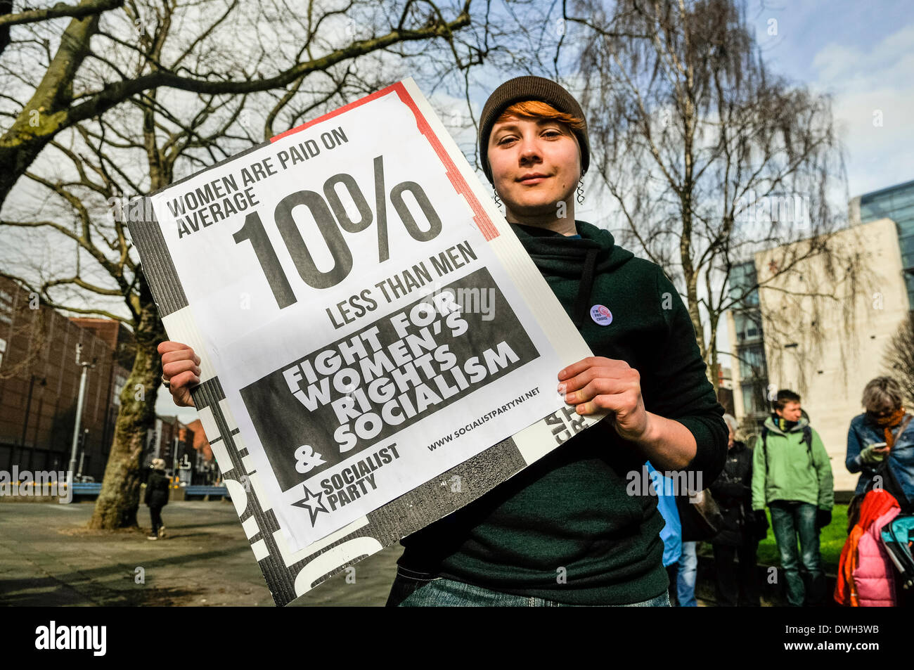 Belfast, Irlanda del Nord. 8 Mar 2014 - Una donna tiene un poster che dice "le donne sono pagate in media il 10% in meno rispetto a quello degli uomini all'inizio della giornata internazionale della donna sfilata Credit: stephen Barnes/Alamy Live News Foto Stock