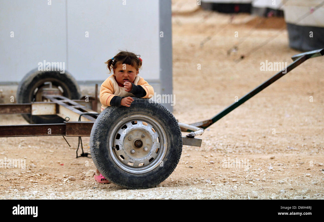 Amman, Giordania. 8 Mar 2014. Un bambino siriano poggia su una carovana della ruota in corrispondenza Zaatari Refugee Camp in città Mafraq, Giordania, il 8 marzo 2014. Più di 90.000 rifugiati siriano attualmente risiedono in Zaatari. © Mohammad Abu Ghosh/Xinhua/Alamy Live News Foto Stock