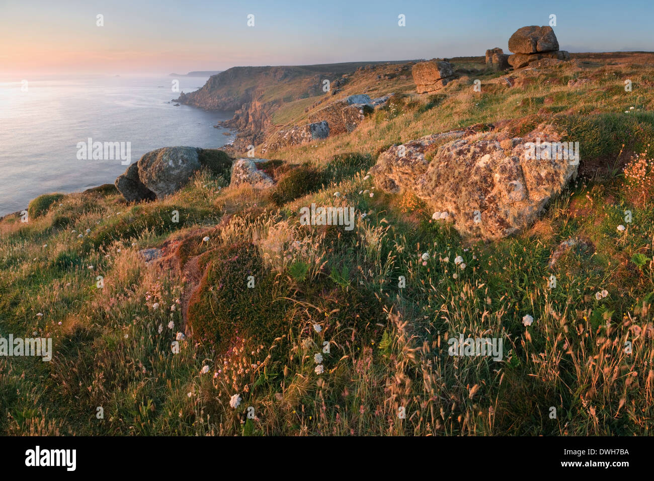 Un vago sole tramonta su Sennen Cove al Land's End, Cornwall in estate. Foto Stock